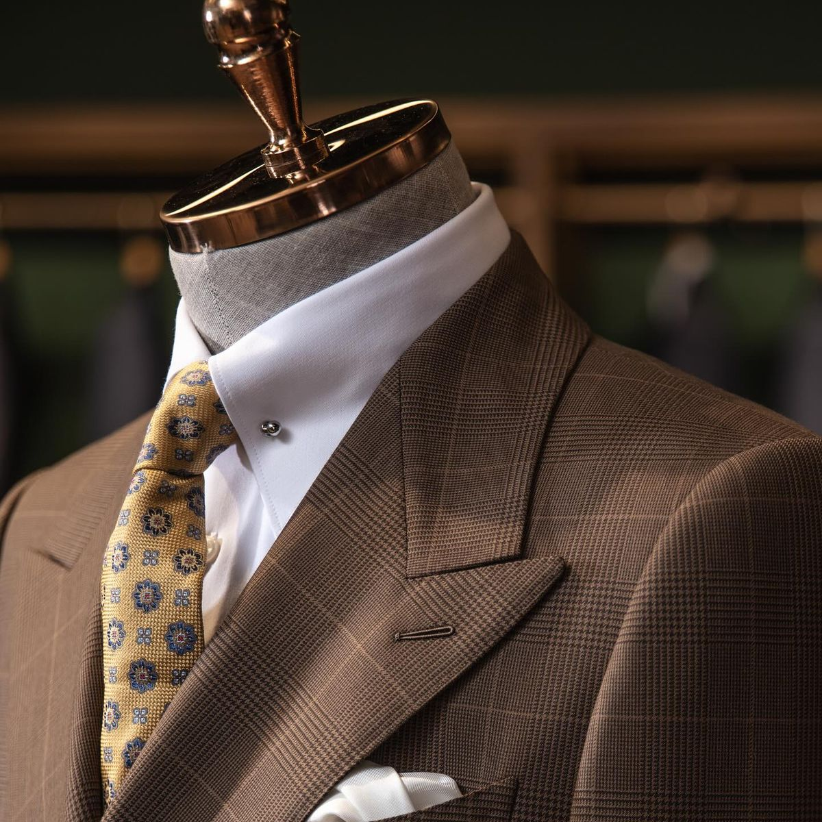 Costum made-to-measure maro în carouri, cu rever ascuțit, expus în showroom-ul INSIGNUM din București.